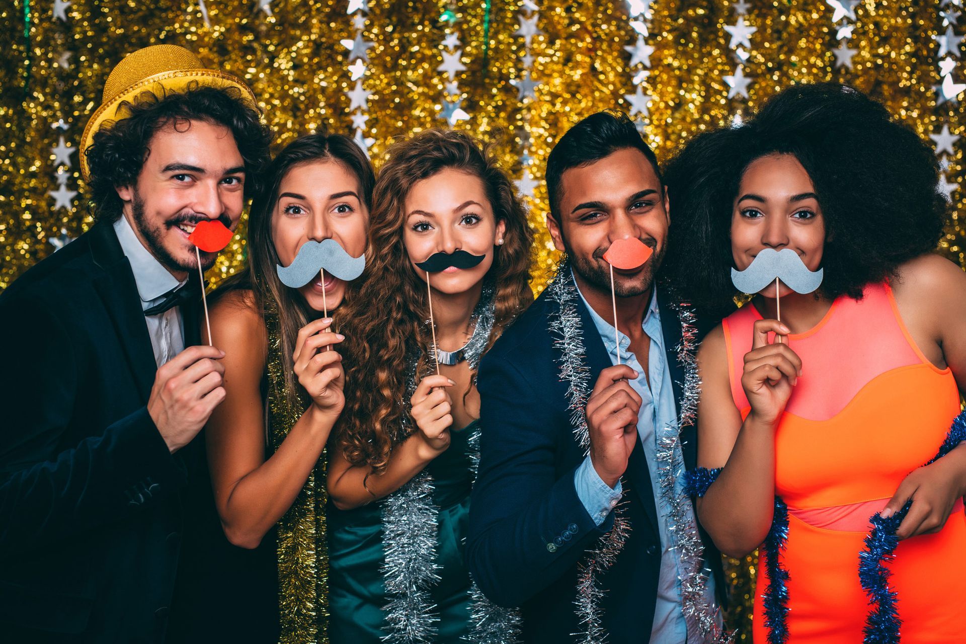 A group of people are posing for a picture with fake mustaches.