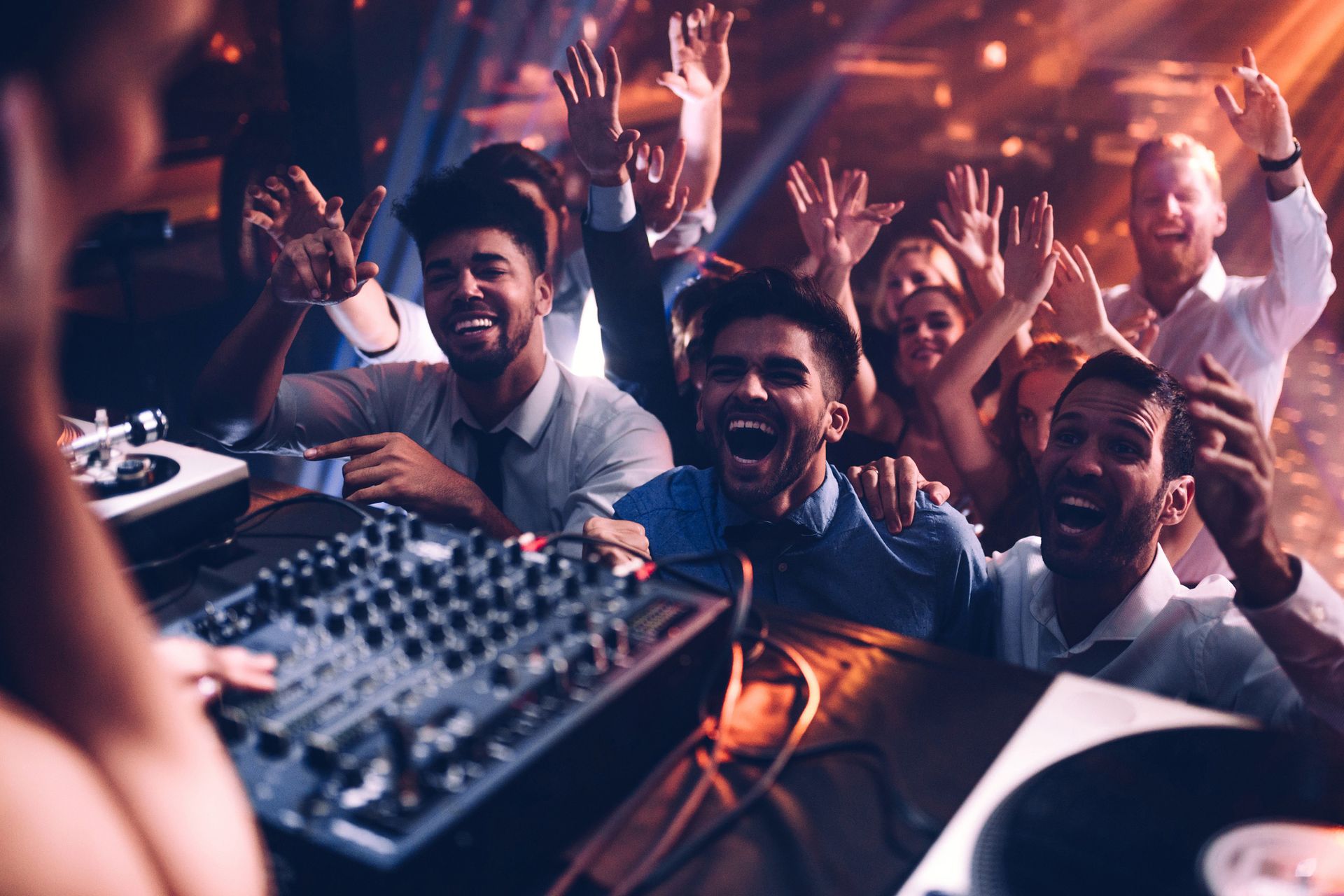 A dj is playing music to a crowd of people at a party.