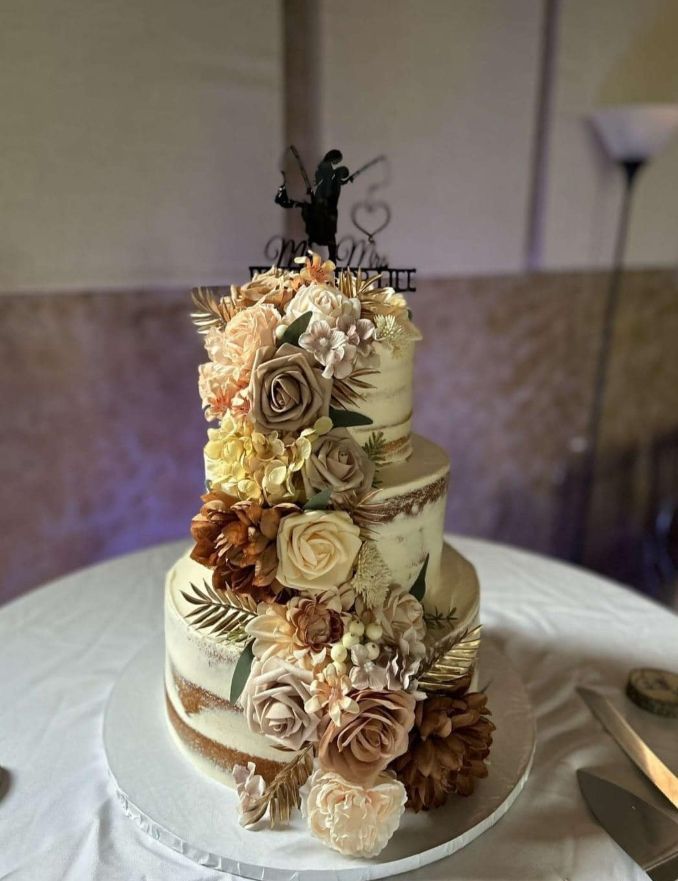 A wedding cake is sitting on top of a white table.