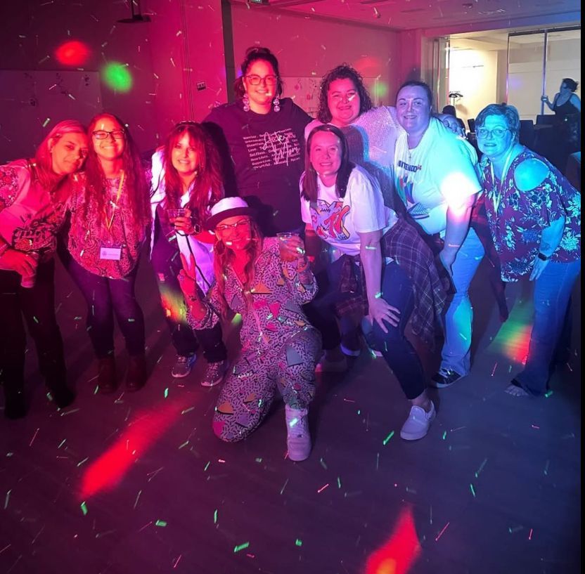 A group of people are posing for a picture in a dark room.