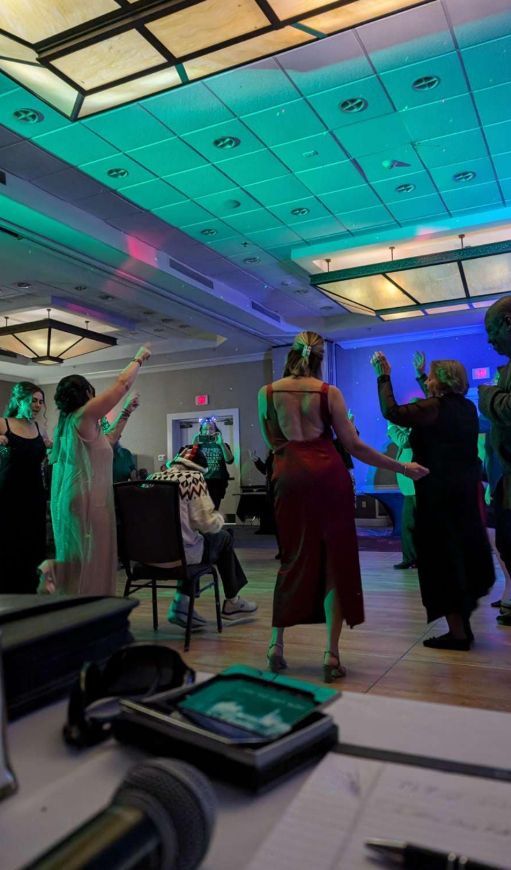 A group of people are dancing in a large room.