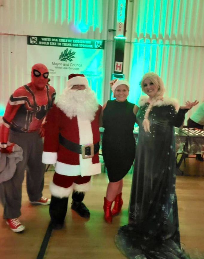 A group of people dressed as santa claus and elsa pose for a picture.