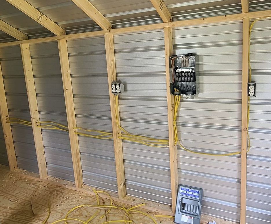 A shed with a lot of wires hanging from the wall.