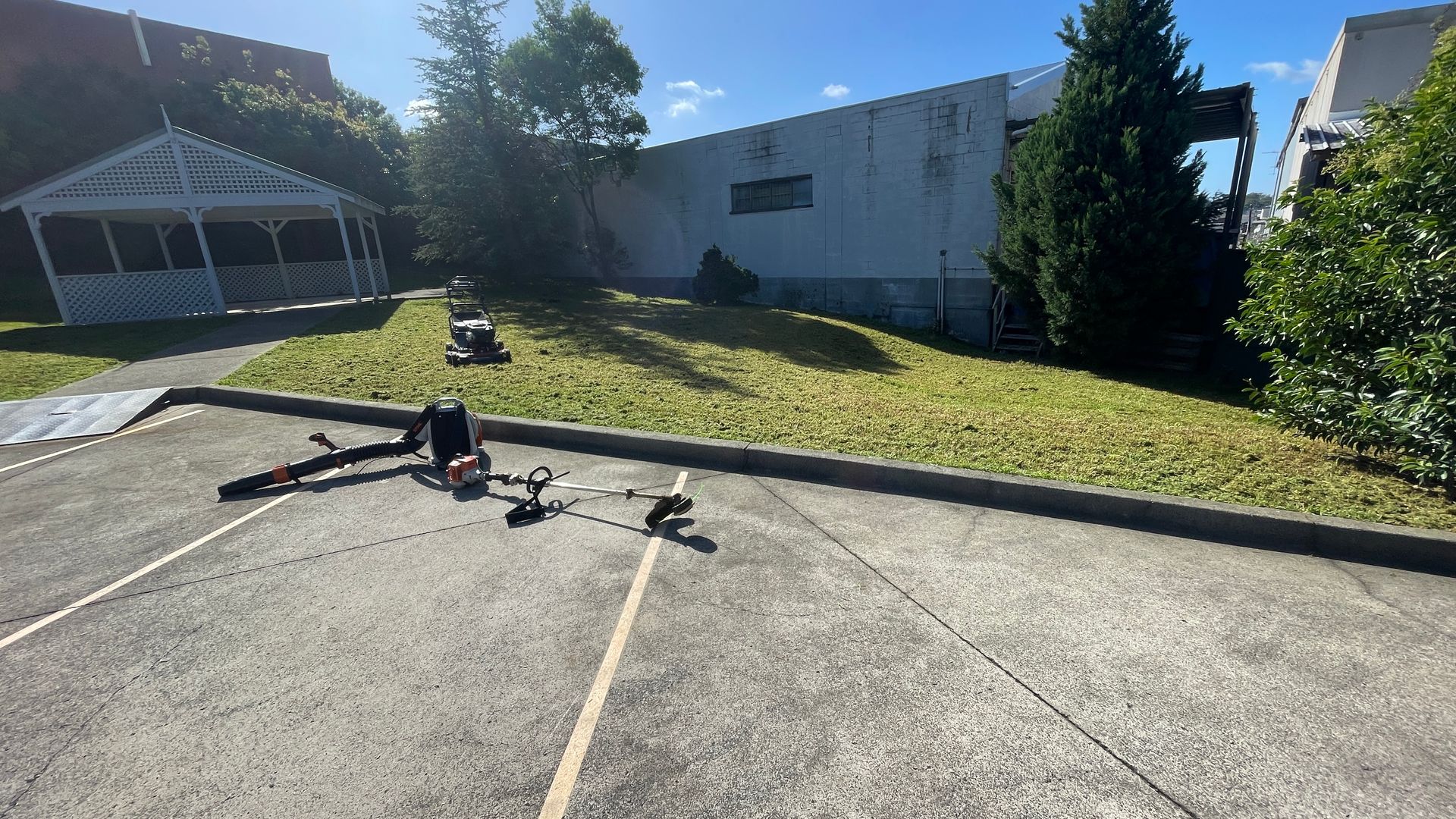 Parking area with low hedge in front of a building.