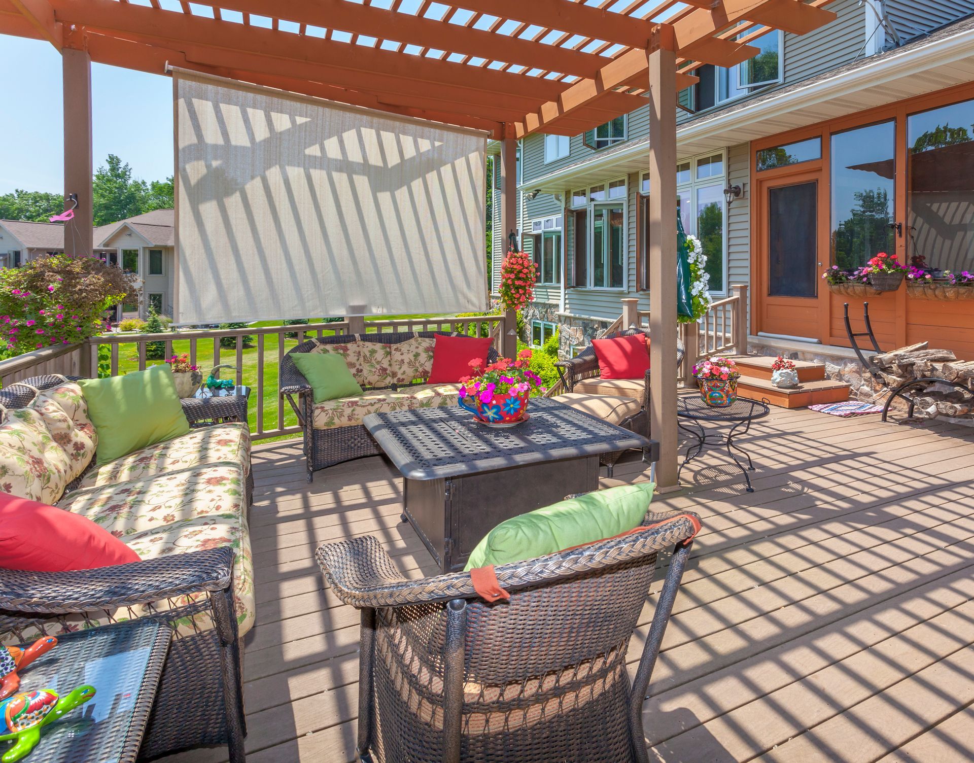 A relaxing outdoor deck patio with a pergola, shaded by stylish and functional outdoor blinds.