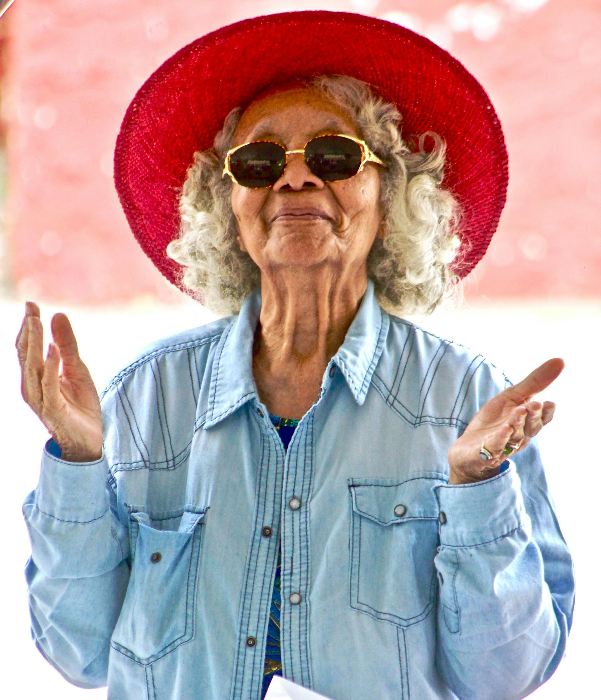 Smiling senior citizen woman in a red hat