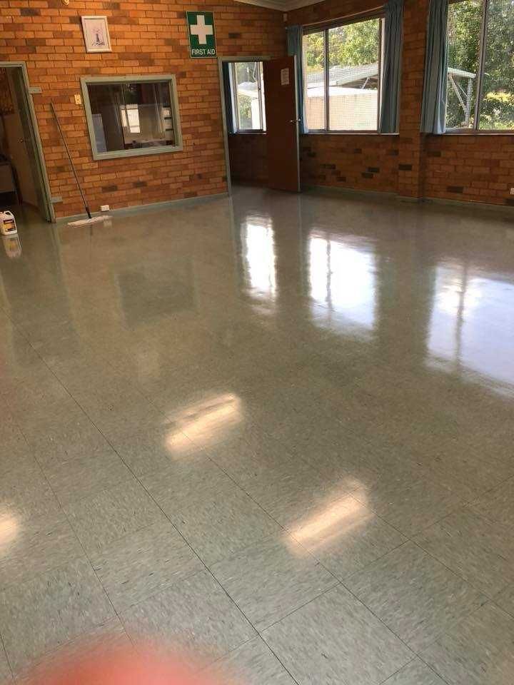 A Large Room With a Brick Wall and a Shiny Floor — Doobies Cleaning Service in Port Macquarie, NSW