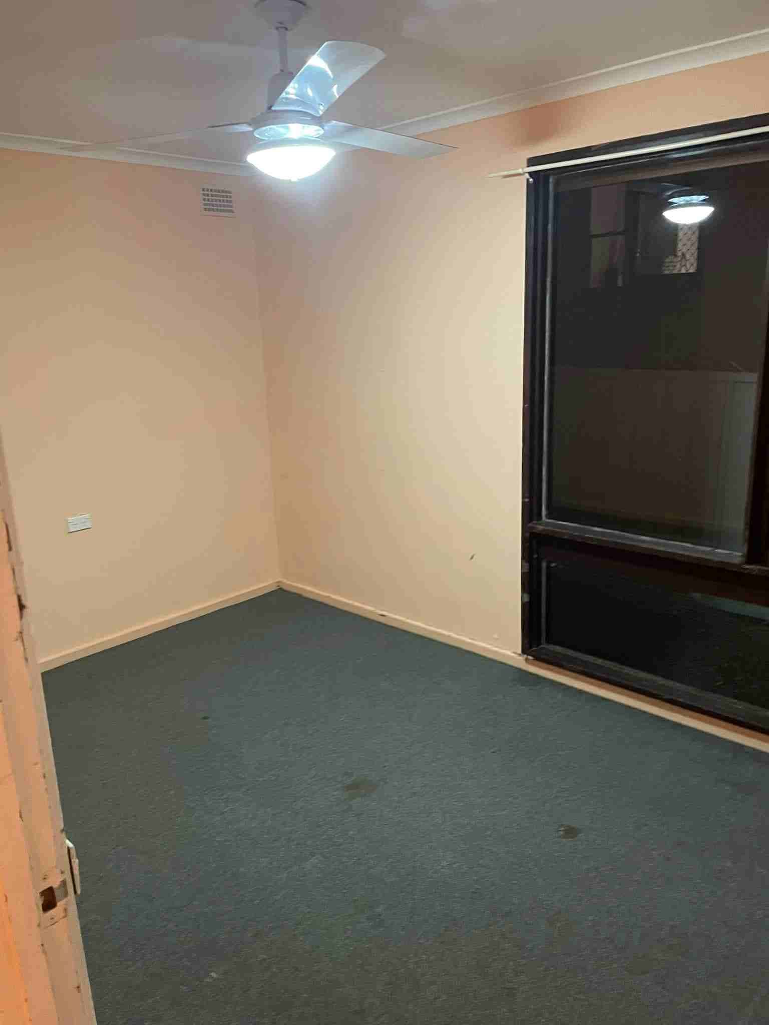 An Empty Room With a Ceiling Fan and a Window — Doobies Cleaning Service in South West Rocks, NSW