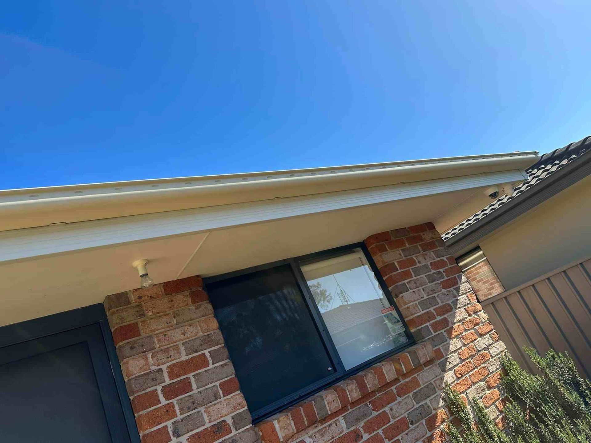 A Brick House With a Window and a Blue Sky in the Background — Doobies Cleaning Service in Kempsey, NSW
