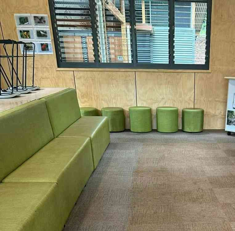 A Waiting Room With a Green Couch and Green Ottomans — Doobies Cleaning Service in Port Macquarie, NSW