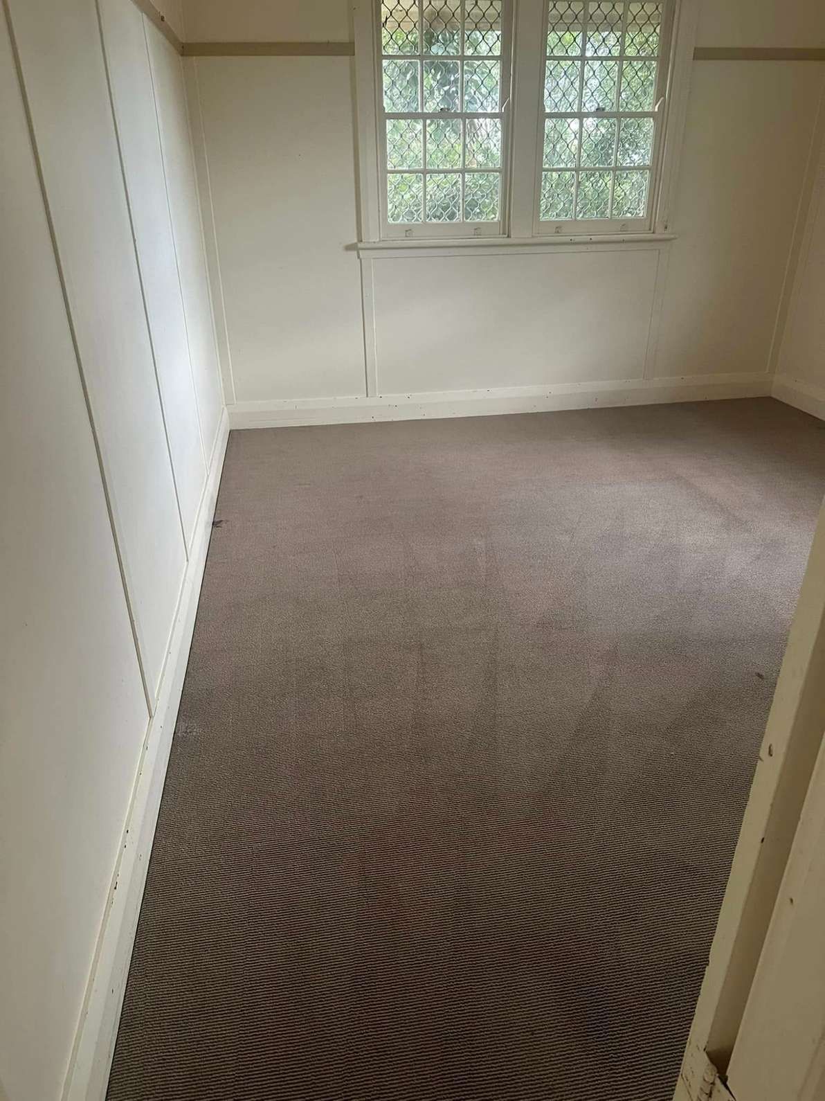 An Empty Room With a Carpeted Floor and Two Windows — Doobies Cleaning Service in South West Rocks, NSW