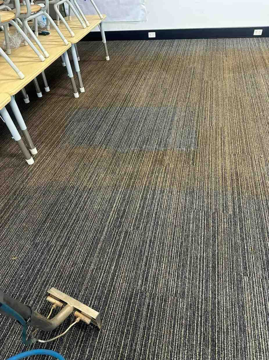 A Vacuum Cleaner is Being Used to Clean a Carpet in a Classroom — Doobies Cleaning Service in Port Macquarie, NSW