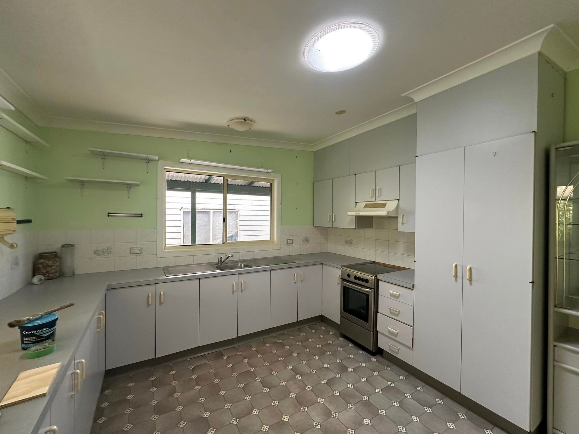 A Kitchen With White Cabinets , a Stove , a Sink , and a Window — Doobies Cleaning Service in Kempsey, NSW