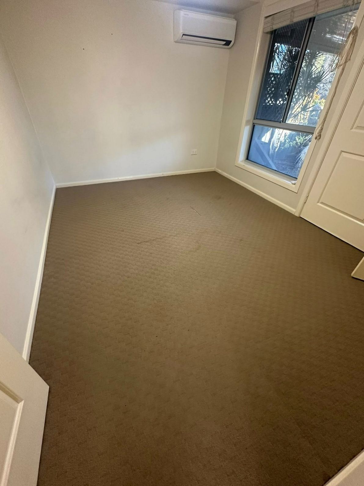 An Empty Room With a Carpeted Floor and a Window — Doobies Cleaning Service in Port Macquarie, NSW