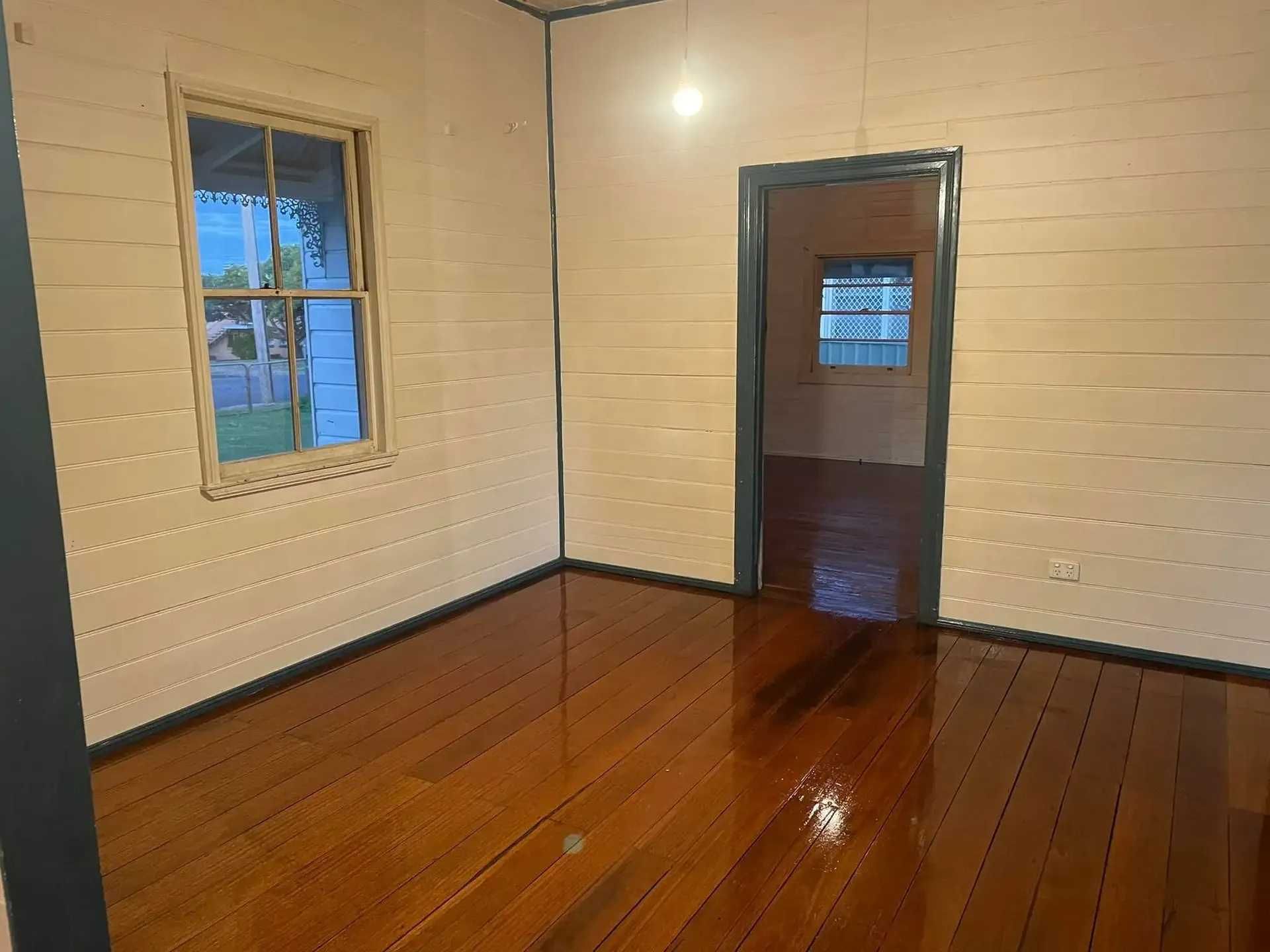 An Empty Room With a Wooden Floor and a Window — Doobies Cleaning Service in Kempsey, NSW