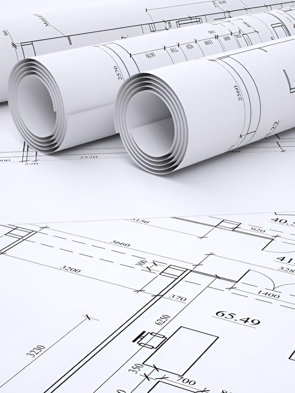 Three Rolls Of Blueprints Are Sitting On Top Of Each Other On A Table — GEO – AM Consulting In Lismore, NSW