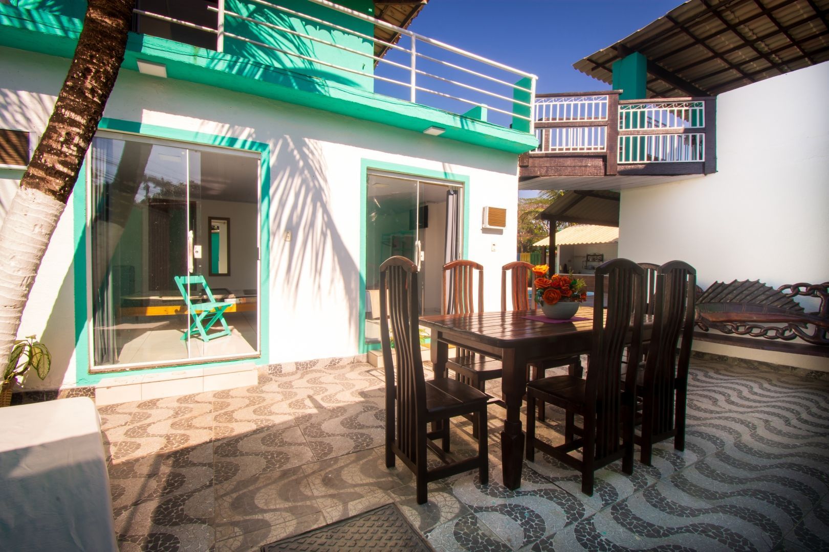 Um pátio com uma mesa e cadeiras em frente a uma casa