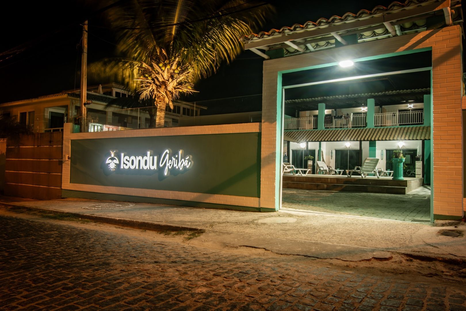 A entrada de um hotel à noite com uma placa que diz 'isandu gulas'.