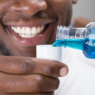 Man Pouring Mouthwash Into Cap — Detroit, MI — Paul Dental Group & Ryan Eight Mile Family Dentistry
