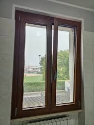 Una finestra con telaio in legno e un termosifone in una stanza.