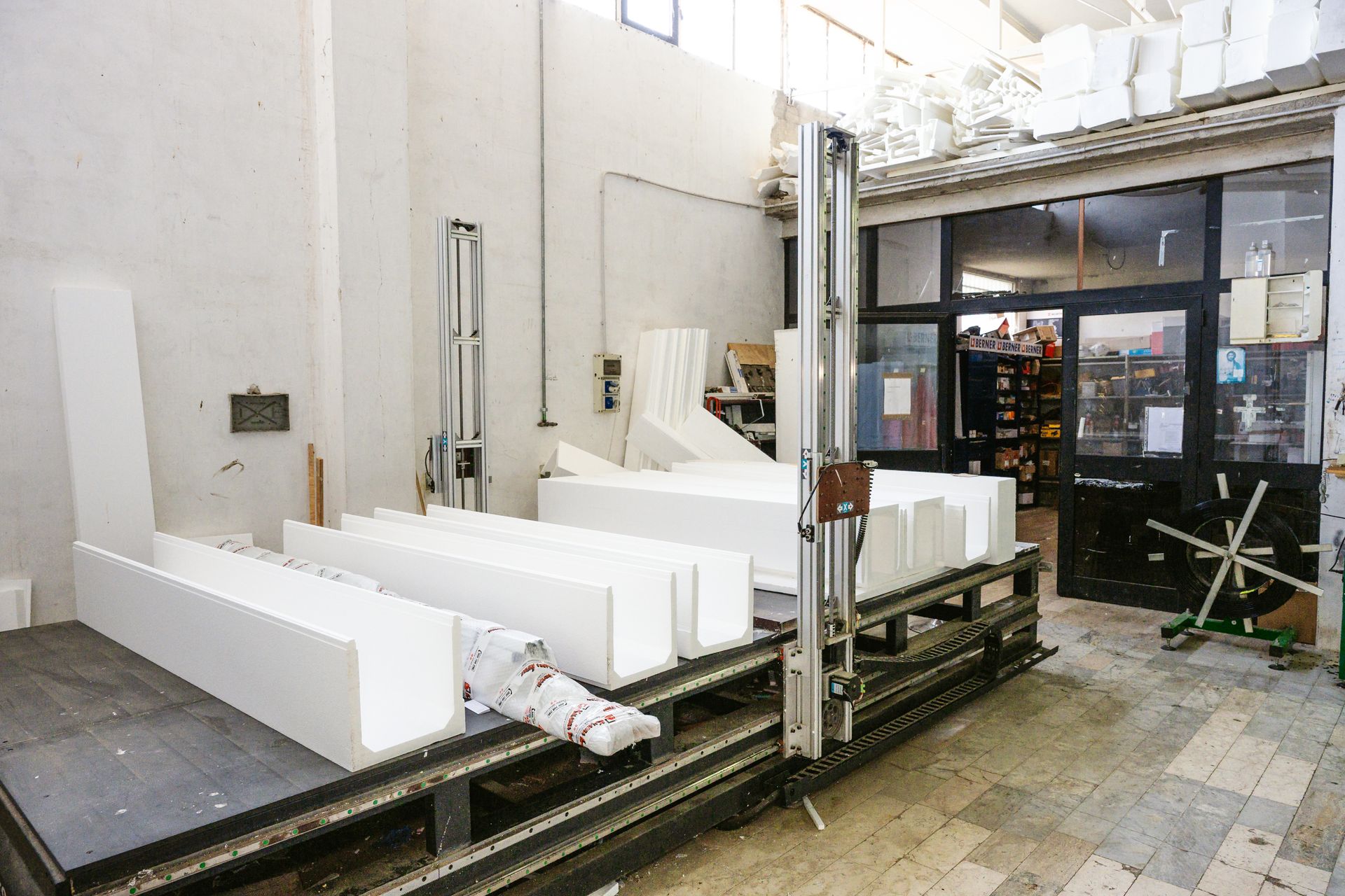 Una macchina sta tagliando blocchi di polistirolo in una fabbrica.