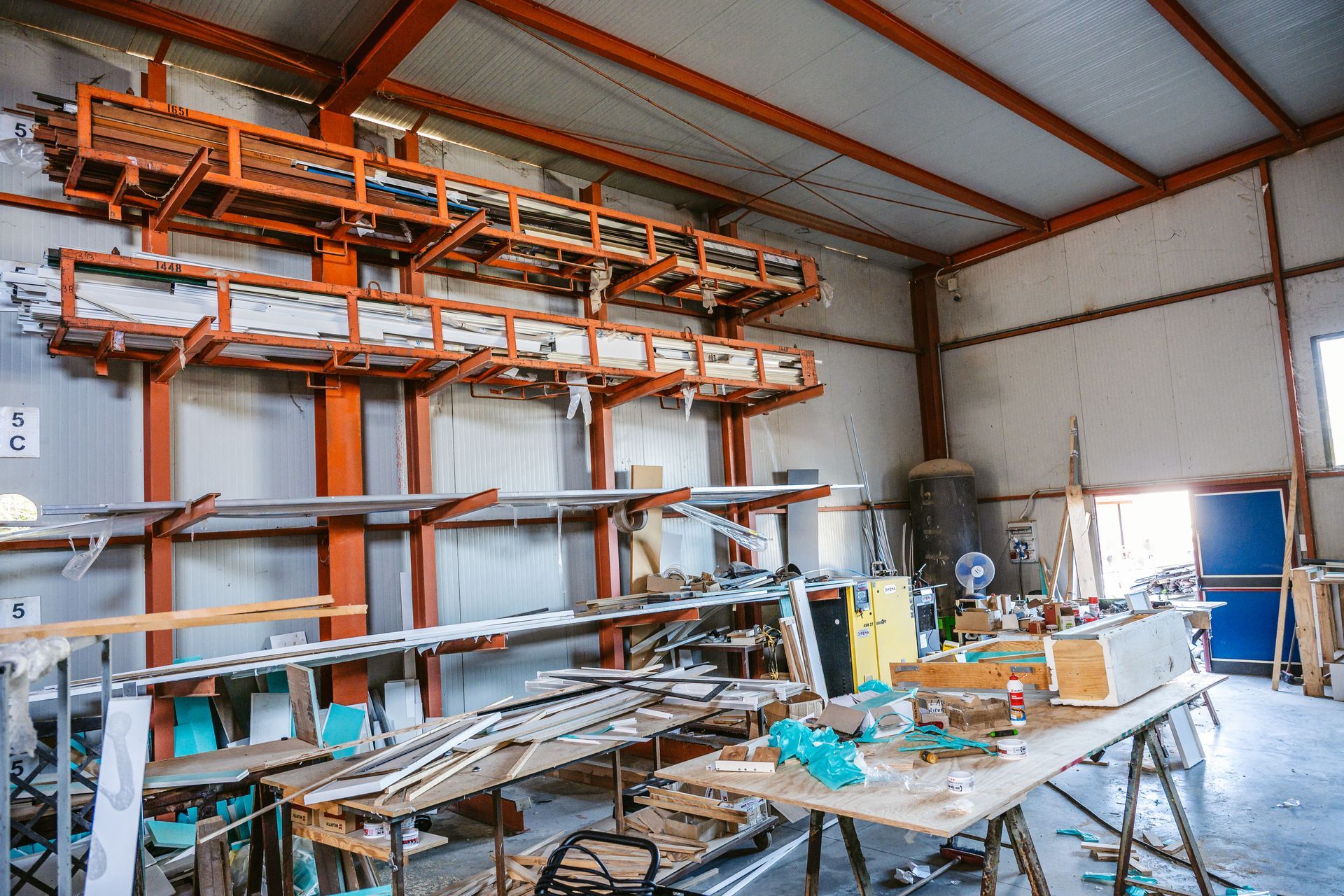 Un magazzino pieno di scaffali e tavoli in legno.