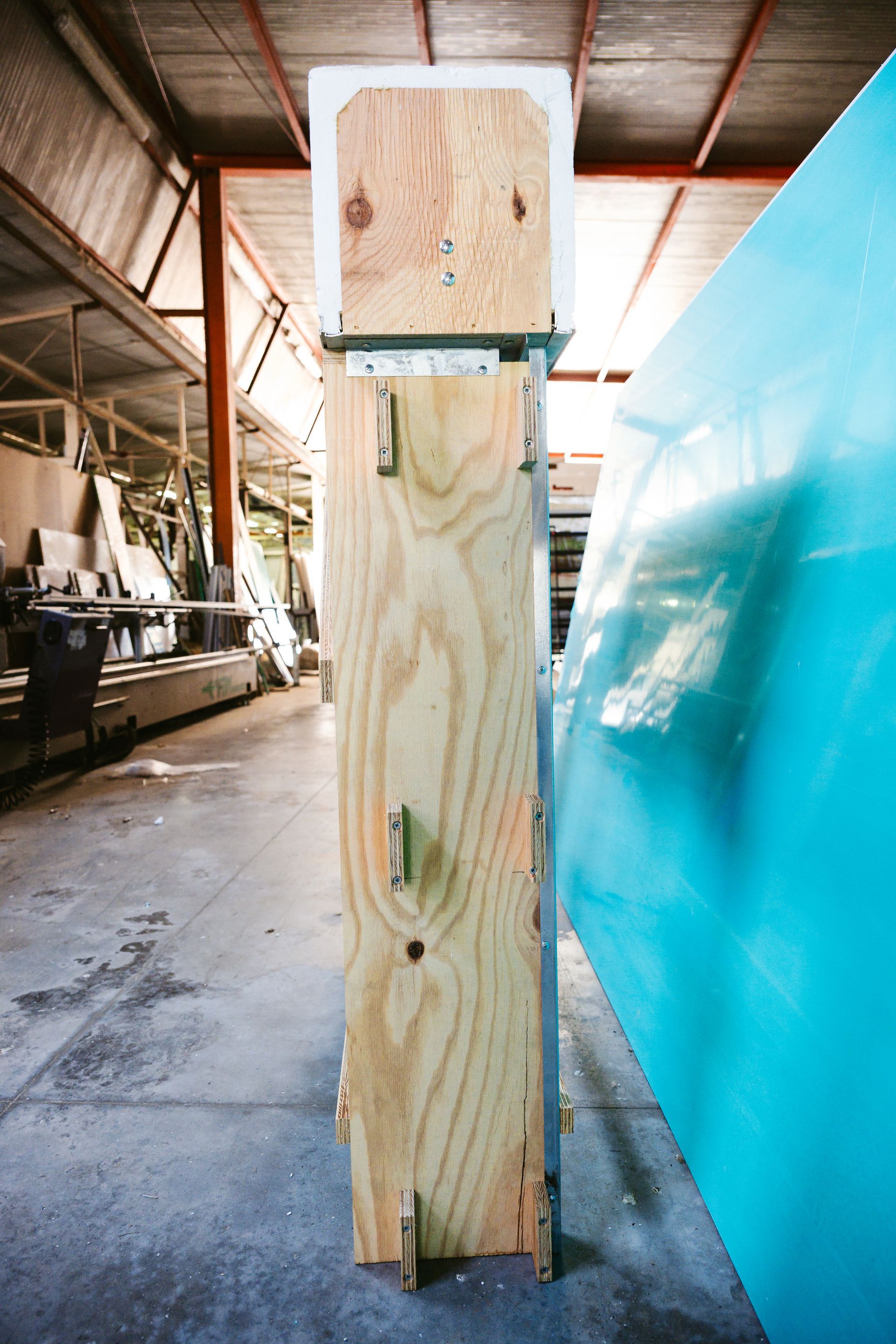 Un grosso pezzo di legno è appoggiato a terra in un magazzino