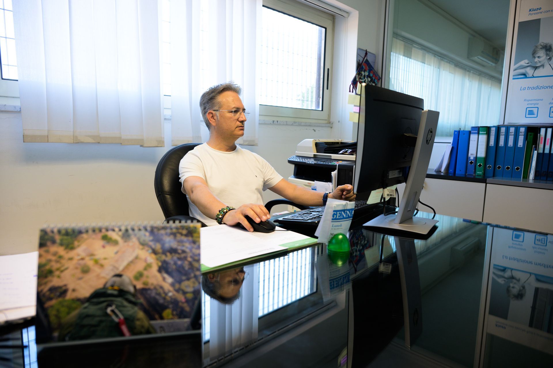 Un uomo è seduto alla scrivania davanti a un computer.