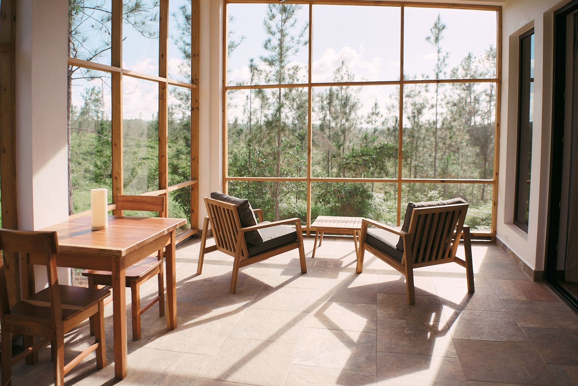 a screened in porch with chairs and a table