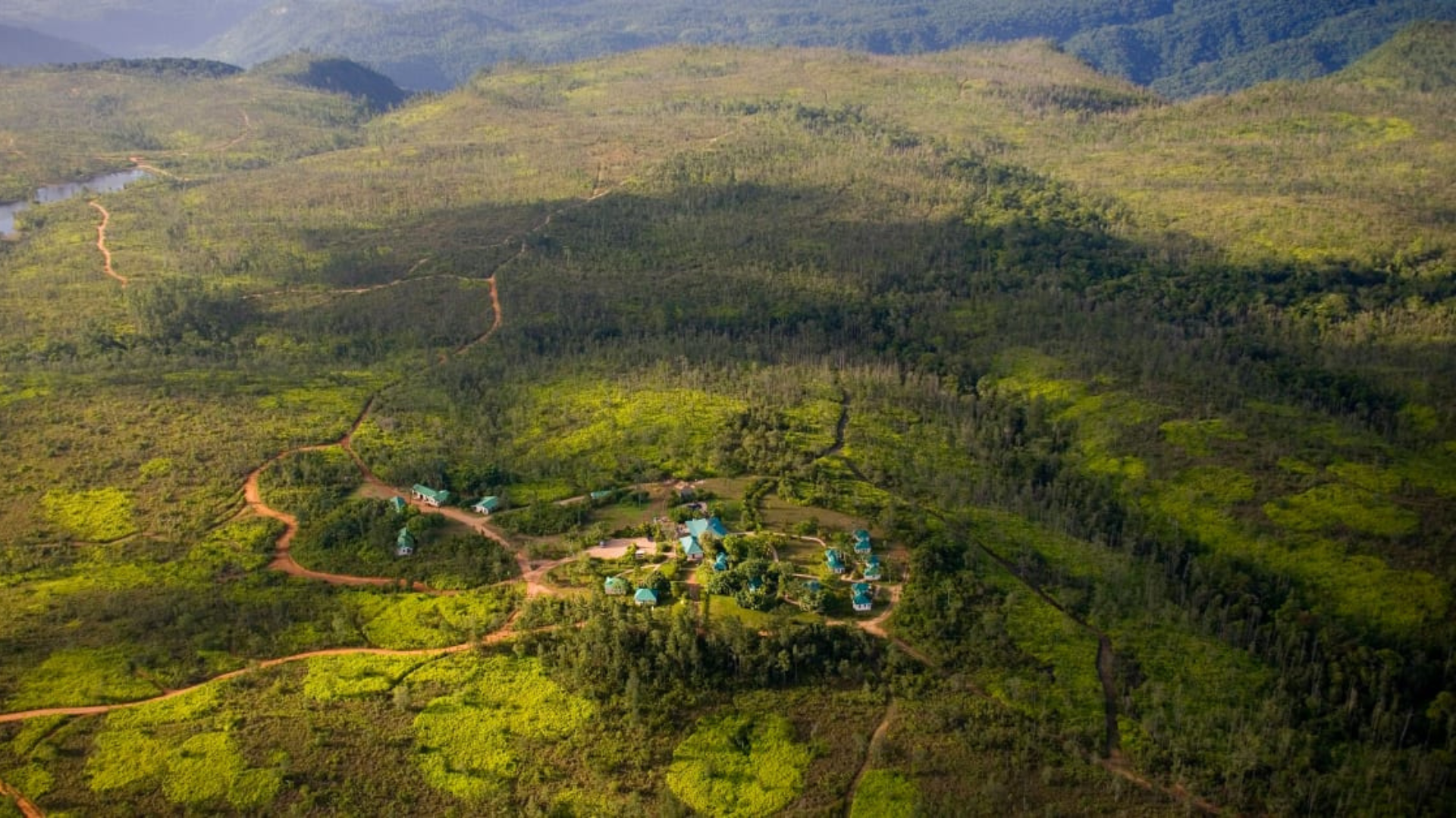 an aerial view of  Hidden Valley Wilderness Lodge, lush green forest with a river running through it .