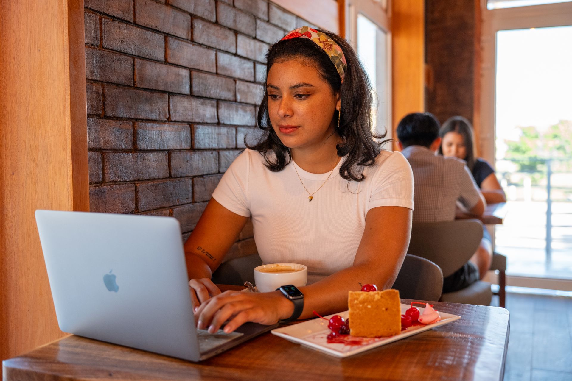 a woman is sitting at a table using a laptop computer .