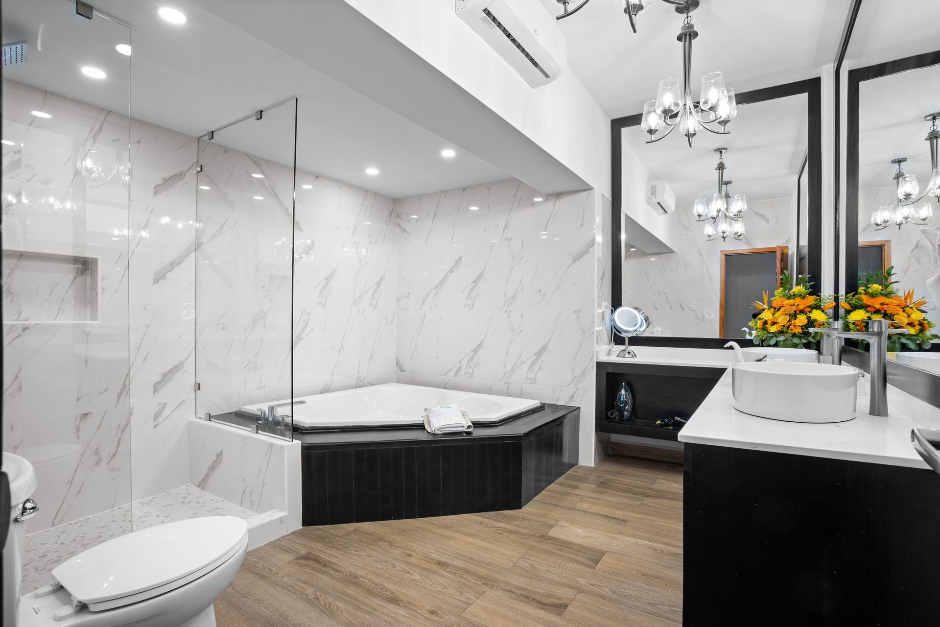 A bathroom with a jacuzzi tub , toilet , sink and mirror.
