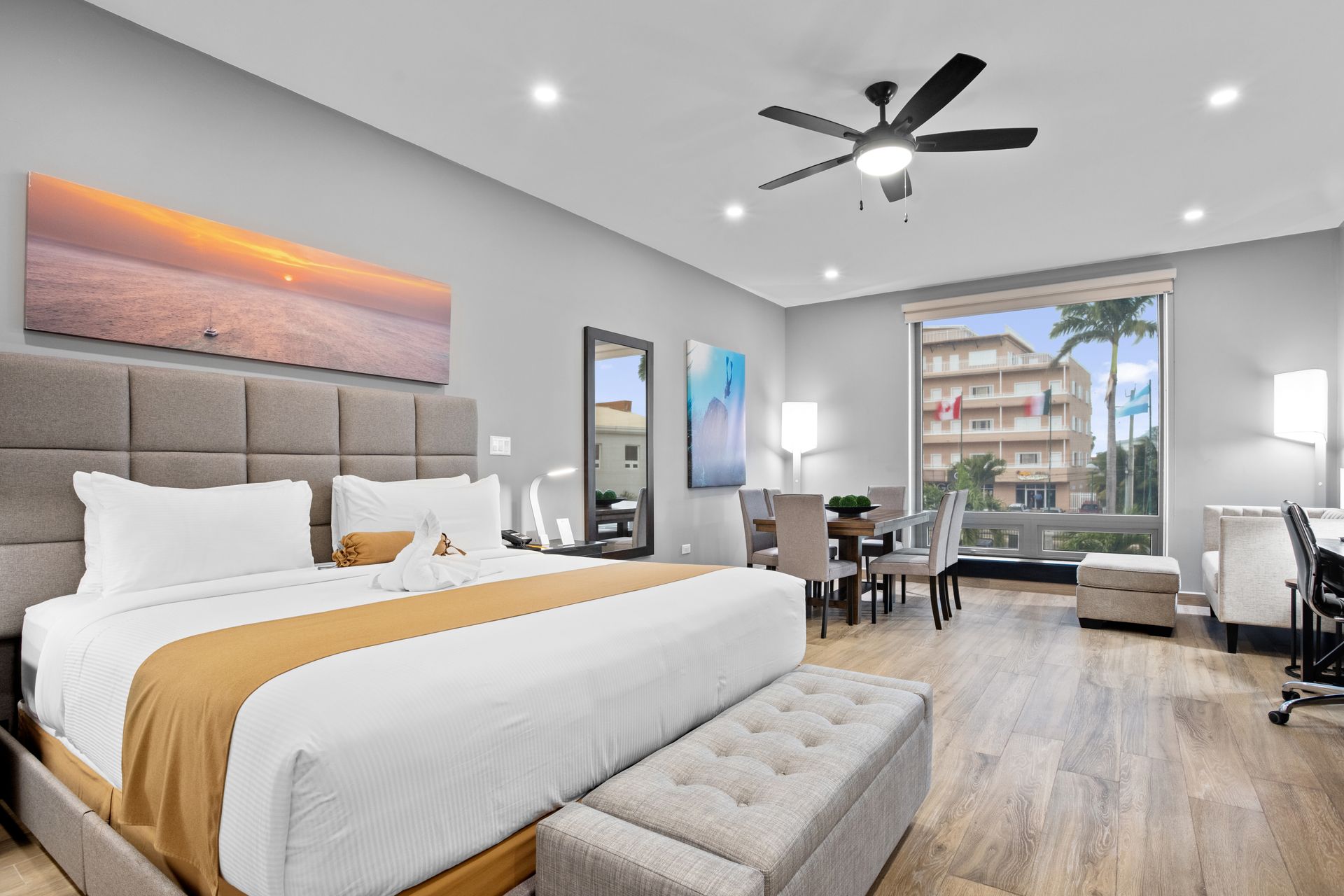 a hotel room with a king size bed and a ceiling fan .