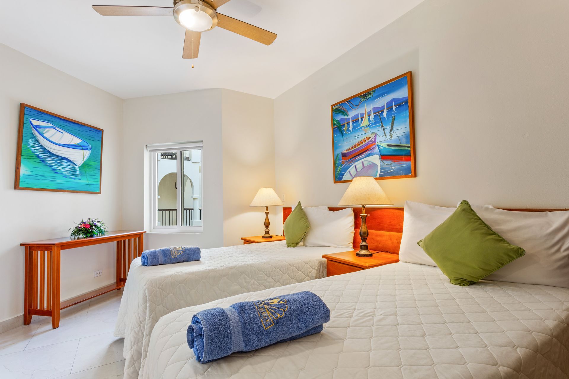 A hotel room with two beds and a ceiling fan