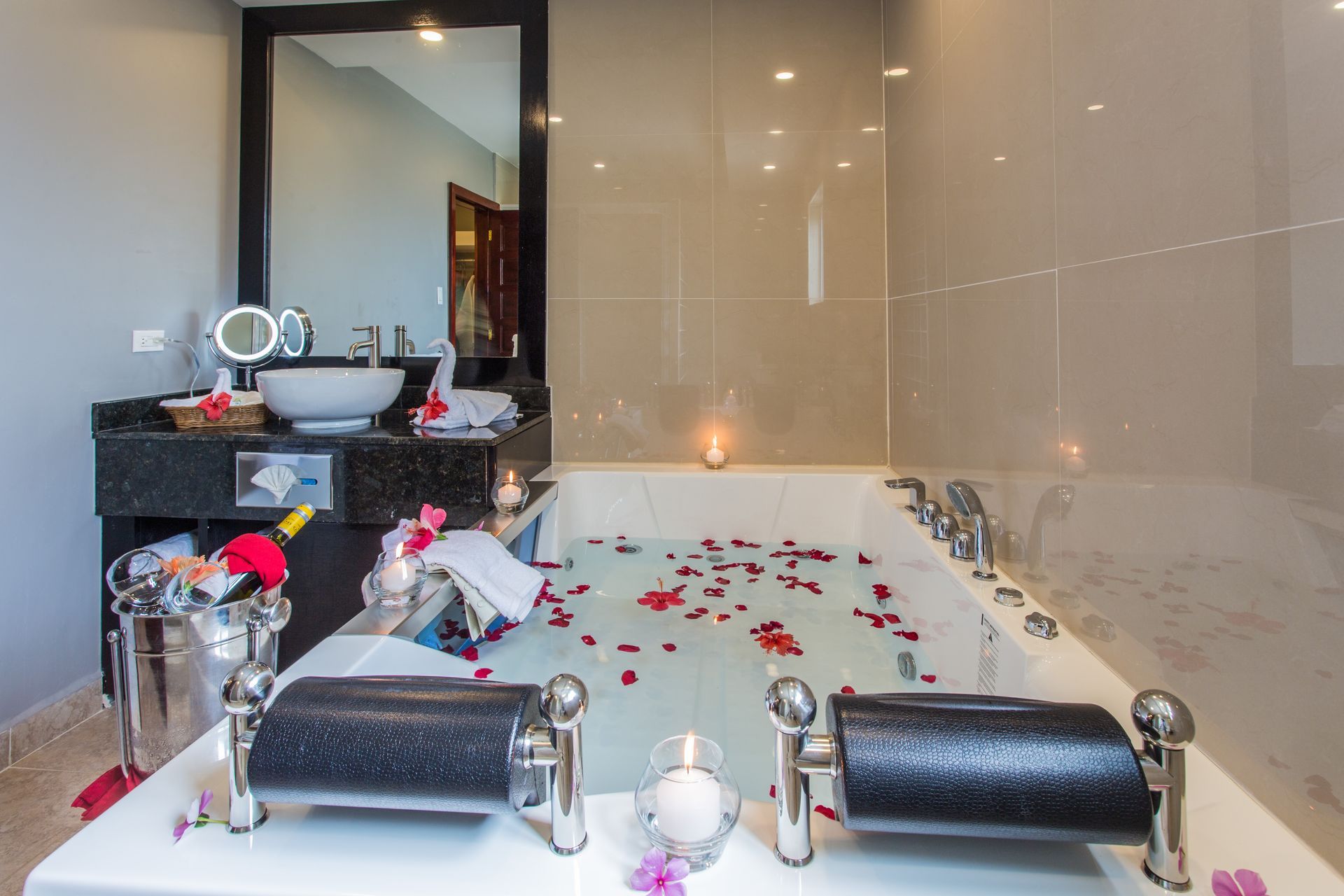 a bathroom with a large bathtub filled with water and rose petals .