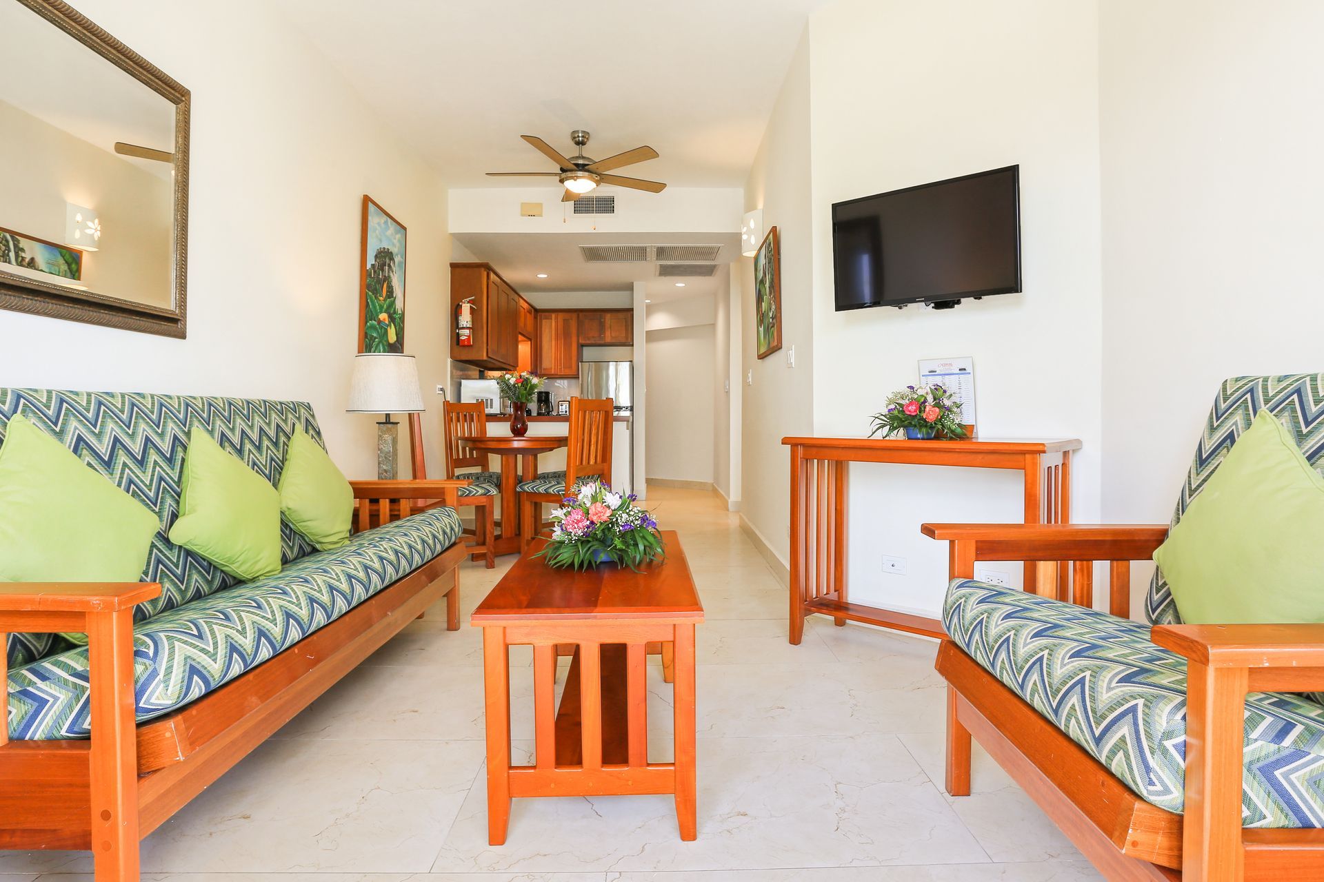 A living room with a couch , chairs , table and television.