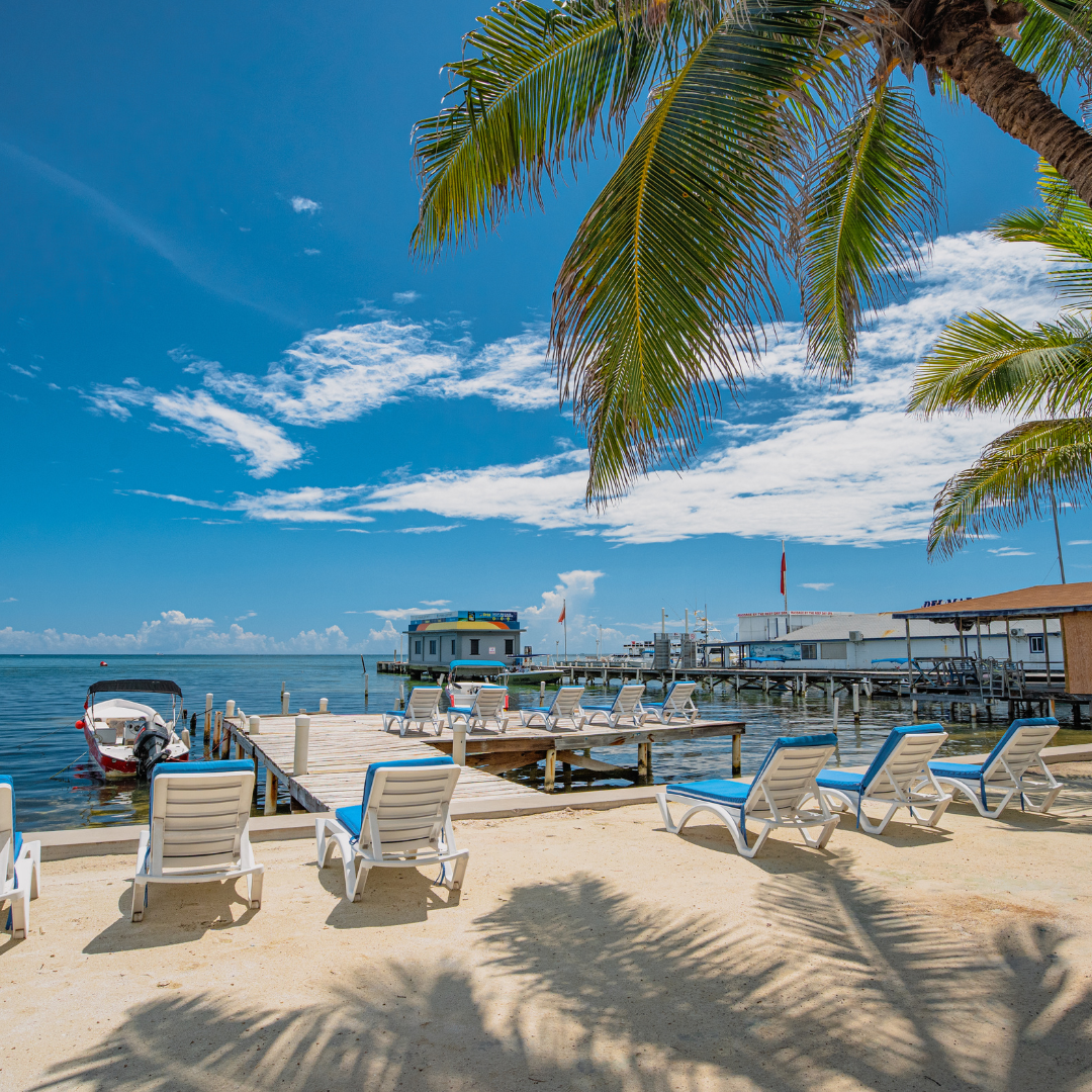 a beach with chairs and a dock with a boat in the water .