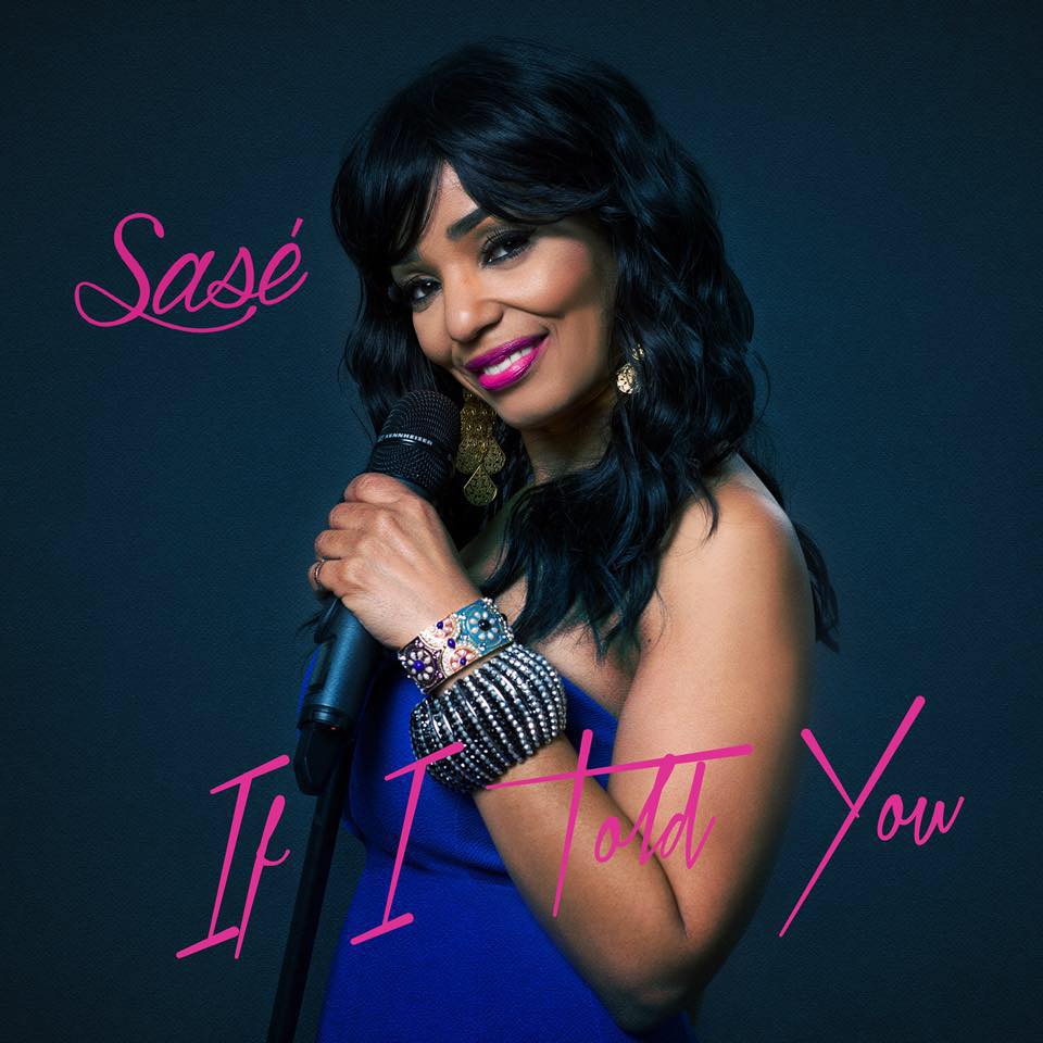 Sasé holding a microphone, smiling with a dark blue dress, against a navy backdrop, the album cover