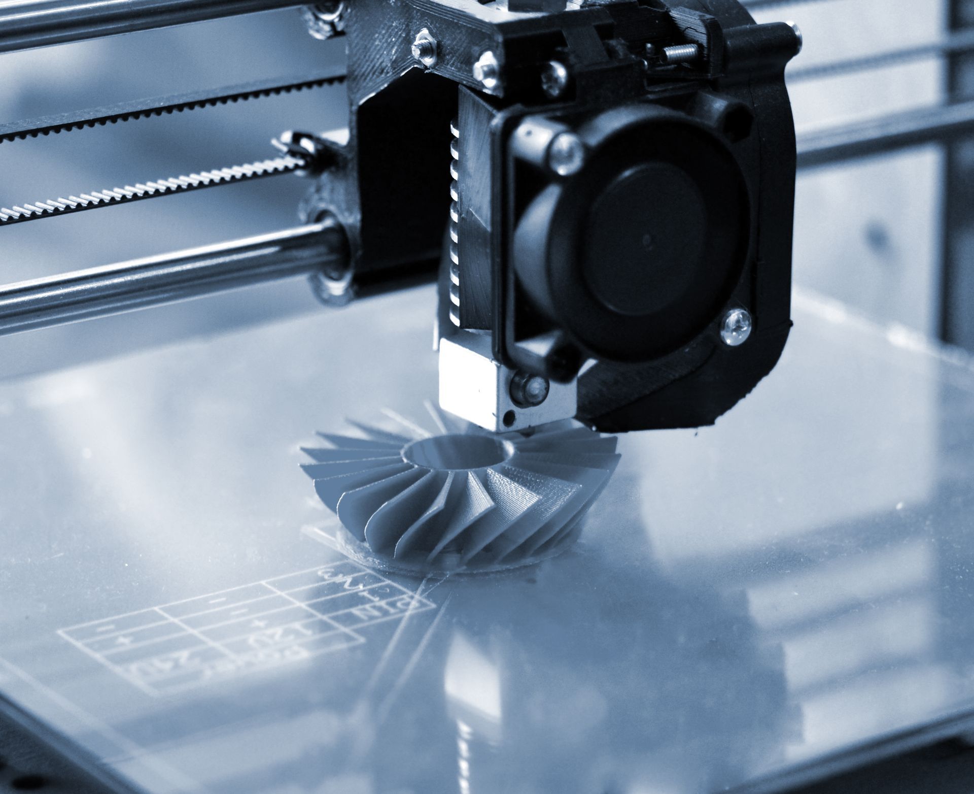 A close up of a 3d printer printing a gear