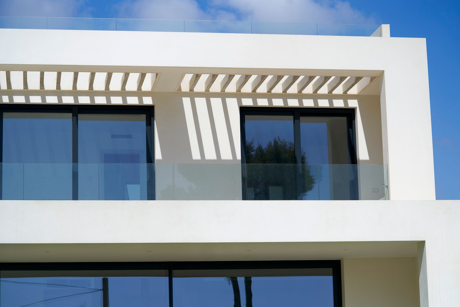 Modern white building with a glass balcony. 
