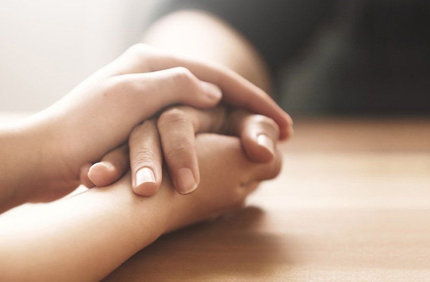 hand holding across a table