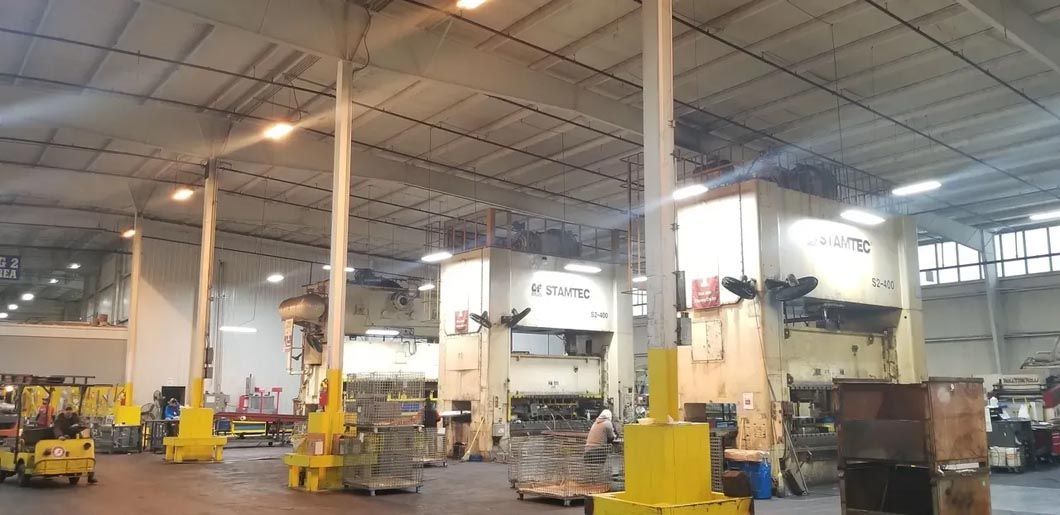 A large warehouse filled with lots of machinery and barrels.