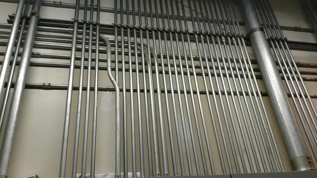 A bunch of metal pipes are hanging on a wall