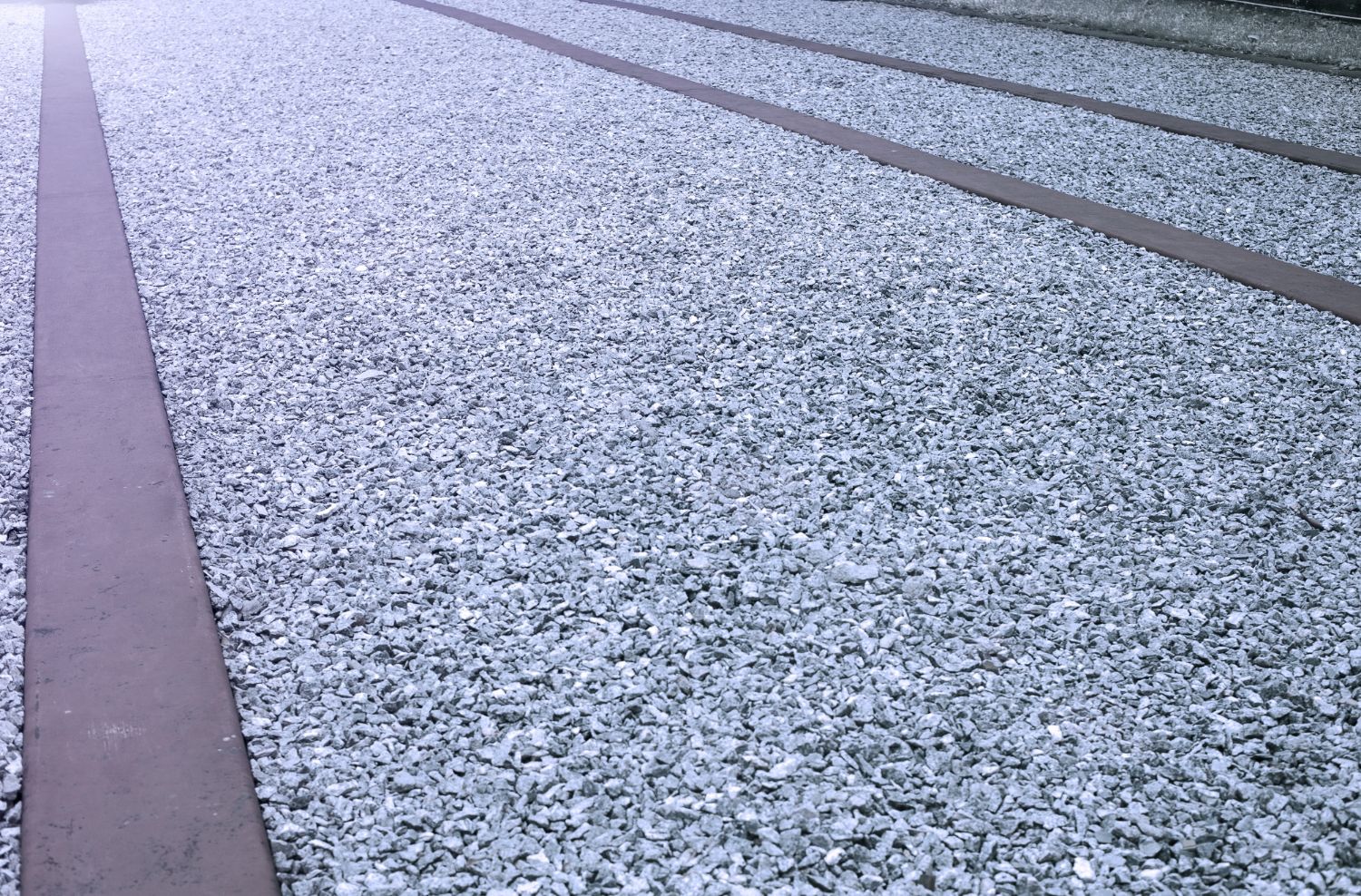 A close up of a gravel road with a few lines on it