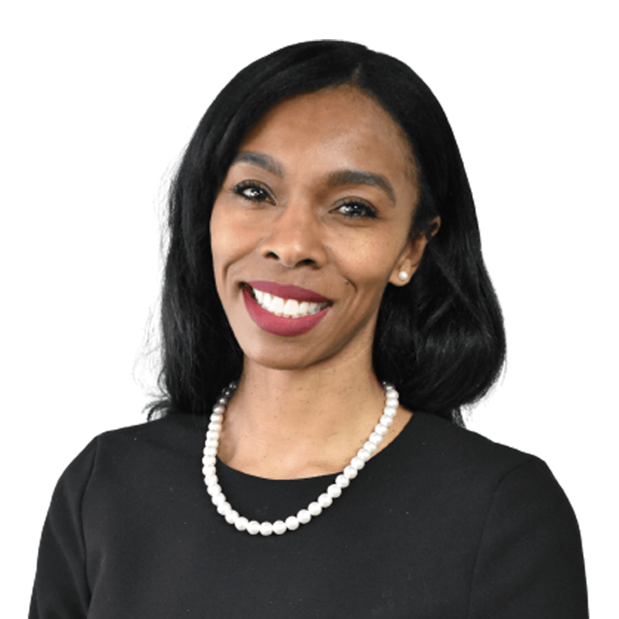 Woman smiling, wearing a black top and pearl necklace.
