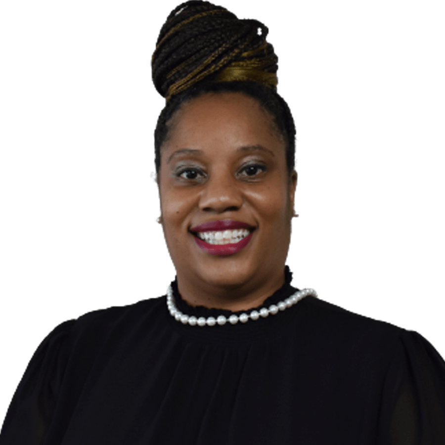 Woman with braided bun smiling, wearing a black top and pearl necklace.