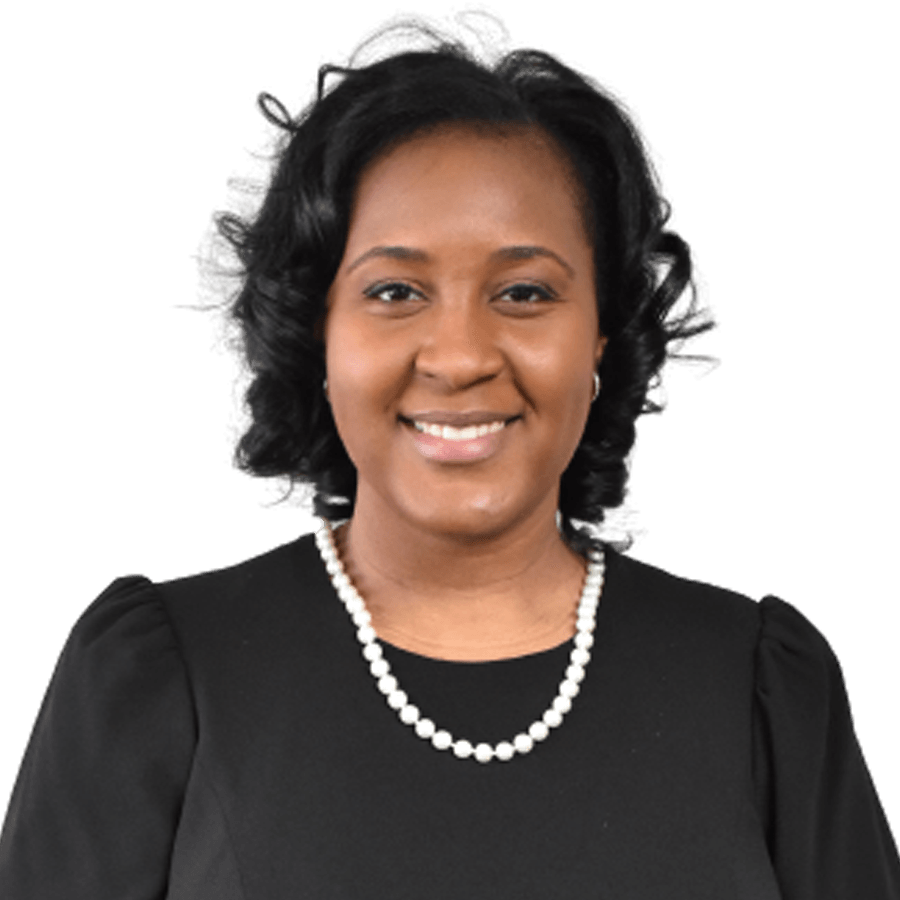 Woman wearing a black top and a pearl necklace, smiling against a white background.