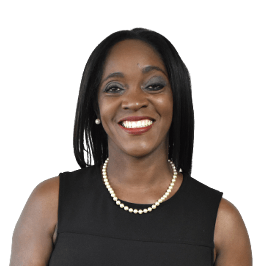 Woman with dark hair, wearing a black sleeveless top and pearl necklace, smiles.