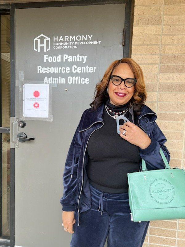 Woman in blue sweatsuit stands in front of a building entrance with the 