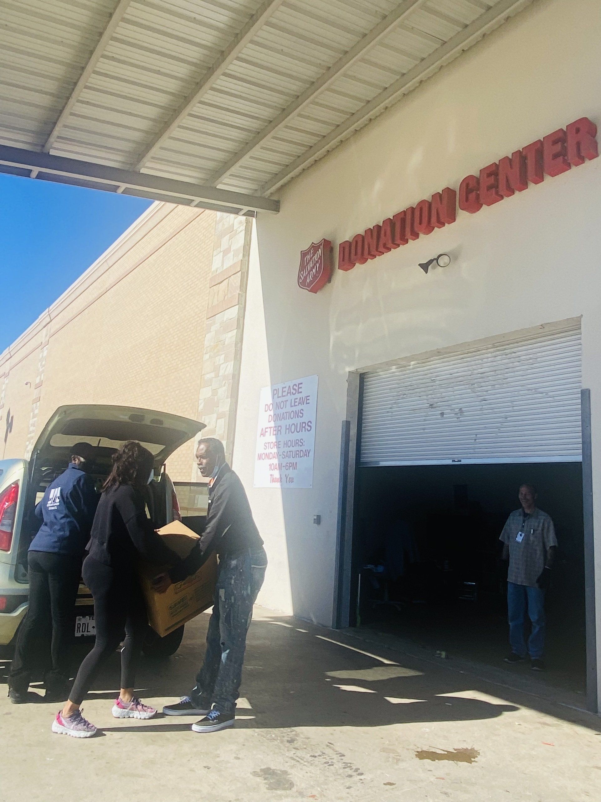 People loading boxes into a building labeled 